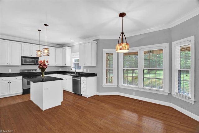 kitchen with stainless steel appliances, dark countertops, white cabinetry, baseboards, and ornamental molding