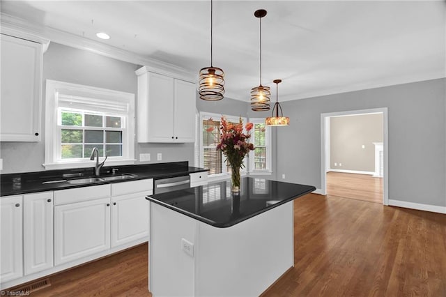 kitchen featuring a sink, dishwasher, dark countertops, dark wood-style floors, and ornamental molding