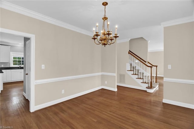 empty room featuring a chandelier, stairway, dark wood-style floors, crown molding, and a sink