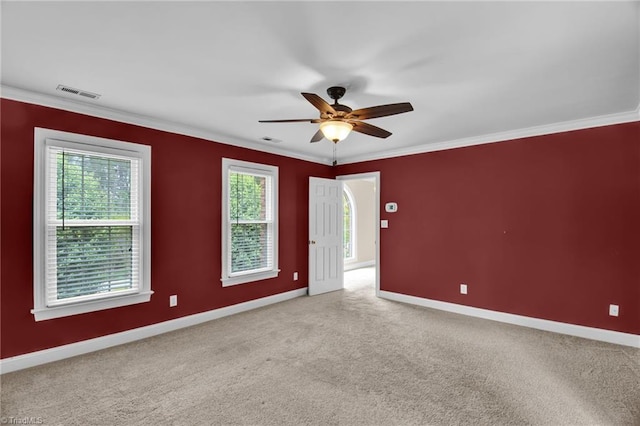 unfurnished room with ceiling fan, baseboards, ornamental molding, and light colored carpet