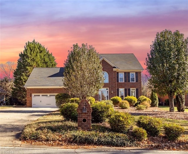 colonial-style house with concrete driveway, a garage, and brick siding