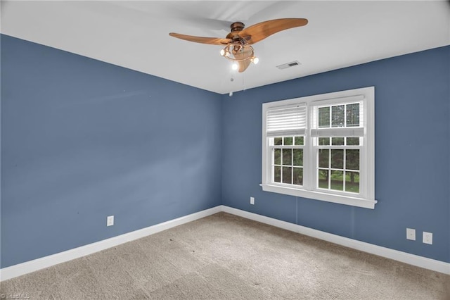carpeted spare room featuring baseboards and ceiling fan