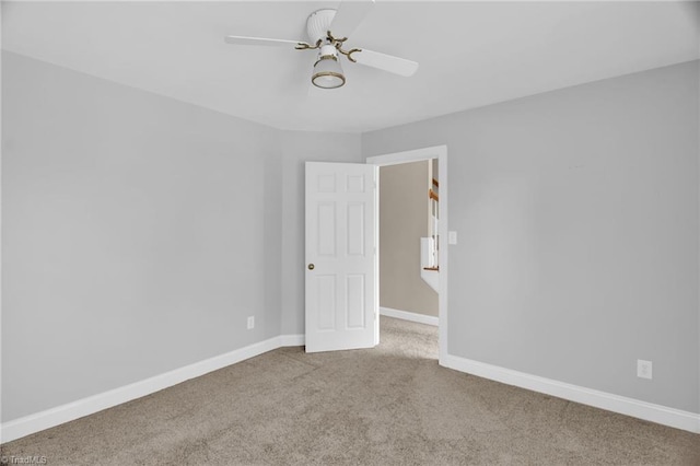 carpeted empty room featuring baseboards
