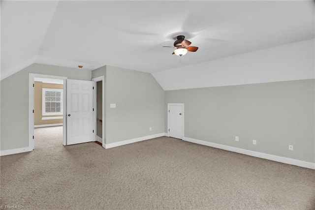 additional living space featuring lofted ceiling, carpet, a ceiling fan, and baseboards