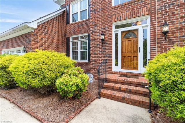 doorway to property featuring brick siding