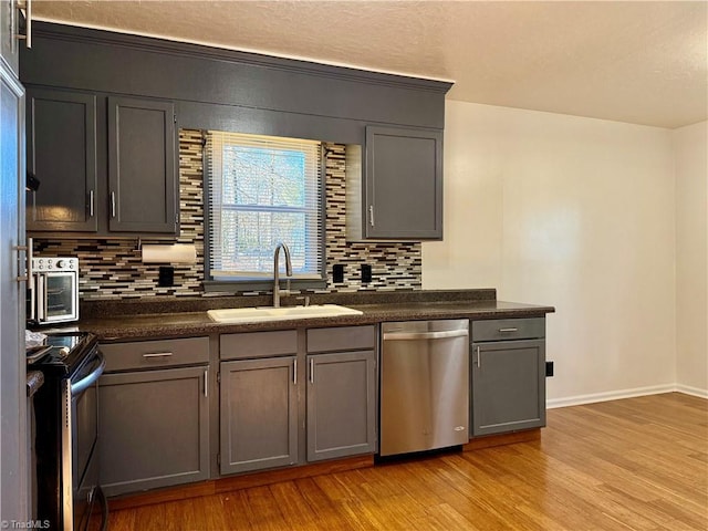 5314 Coble Church Rd, Julian, NC 27283 - kitchen with a sink, stainless steel appliances, dark countertops, and light wood finished floors