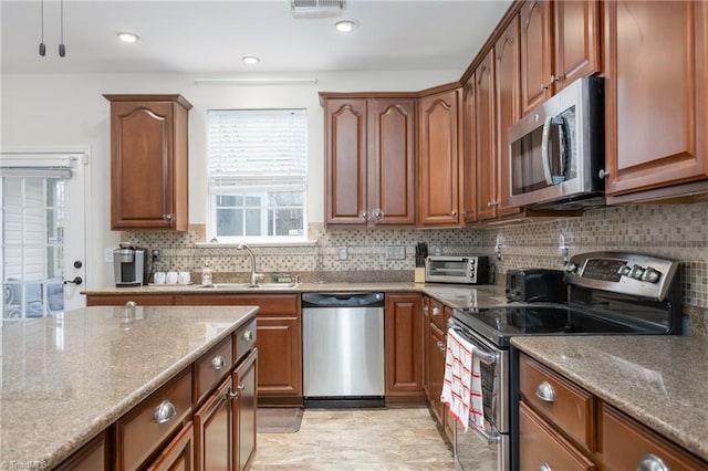 kitchen with recessed lighting, a toaster, stainless steel appliances, a sink, and backsplash