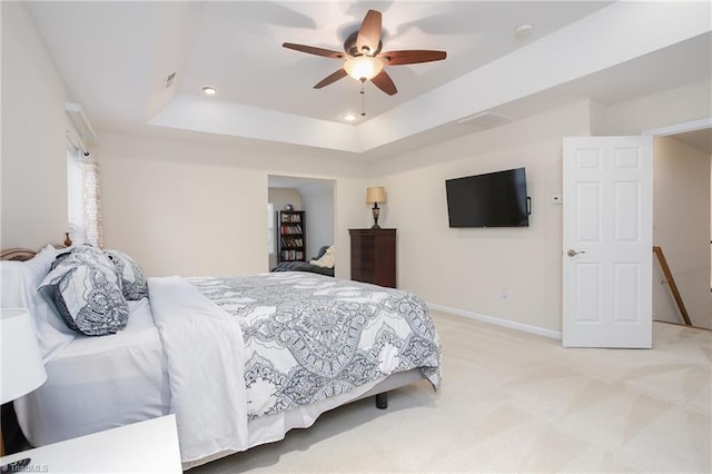 bedroom featuring baseboards, a ceiling fan, light colored carpet, a tray ceiling, and recessed lighting