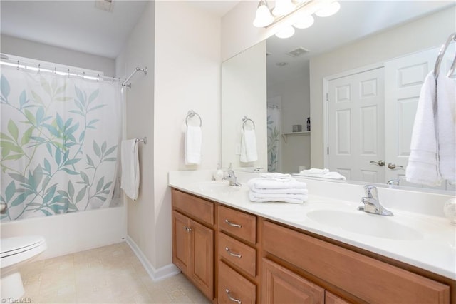 full bathroom featuring toilet, double vanity, a sink, and visible vents