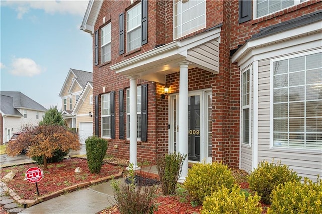 doorway to property featuring brick siding