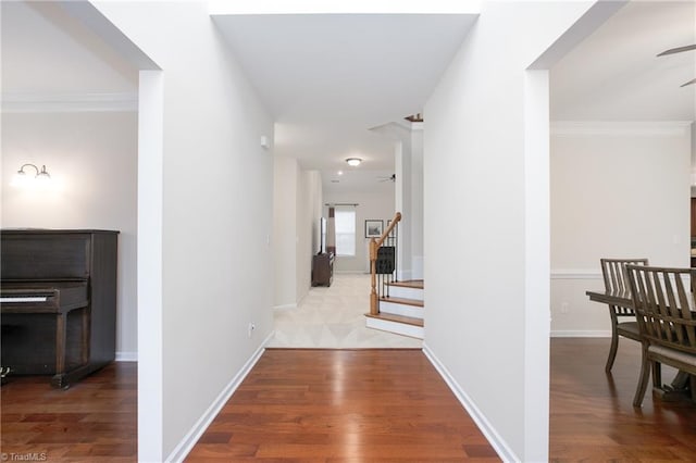 hall with stairs, ornamental molding, wood finished floors, and baseboards