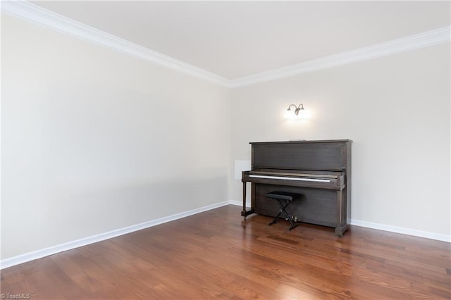 unfurnished room with ornamental molding, baseboards, and wood finished floors