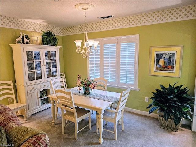 dining space with light colored carpet, a textured ceiling, and a notable chandelier