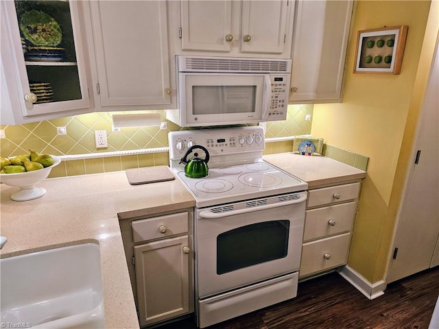 kitchen with dark hardwood / wood-style flooring, white cabinets, sink, backsplash, and white appliances