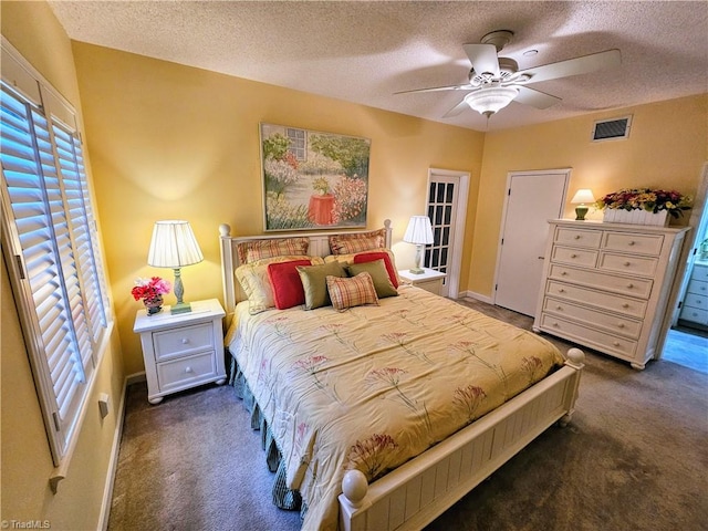 bedroom featuring a textured ceiling, ceiling fan, and dark carpet