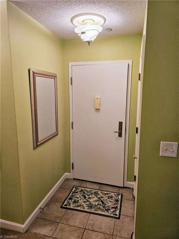 entryway featuring a textured ceiling and light tile patterned floors