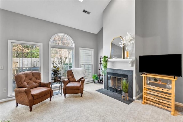 carpeted living room with high vaulted ceiling