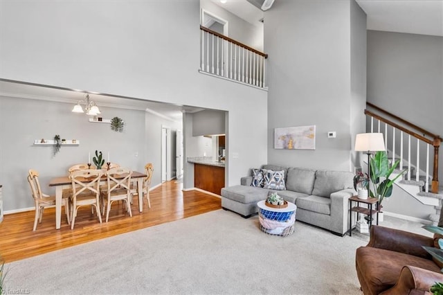 living room with an inviting chandelier, a towering ceiling, and wood-type flooring