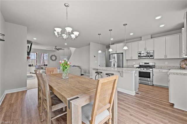 dining area featuring recessed lighting, light wood-style floors, baseboards, and ceiling fan with notable chandelier