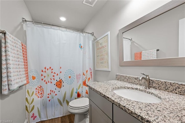 bathroom featuring wood finished floors, vanity, toilet, visible vents, and recessed lighting