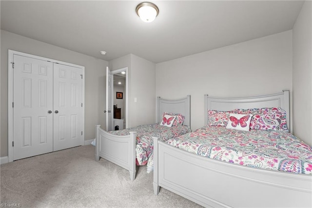 bedroom featuring light carpet, baseboards, and a closet