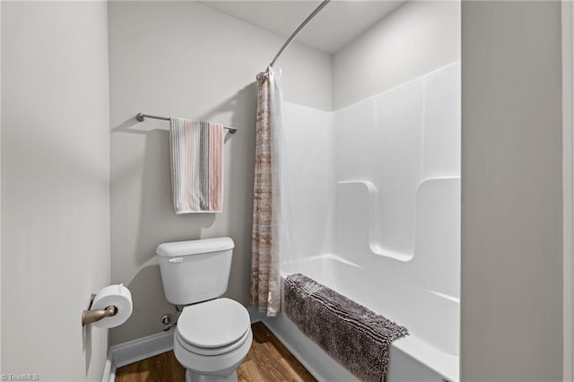 full bathroom featuring baseboards, wood finished floors, toilet, and shower / tub combo with curtain