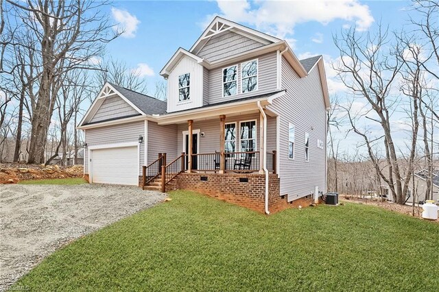 view of front facade featuring central AC, crawl space, covered porch, a front yard, and a garage