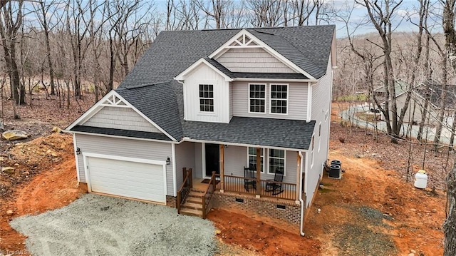 traditional home featuring driveway, a porch, a garage, a shingled roof, and board and batten siding