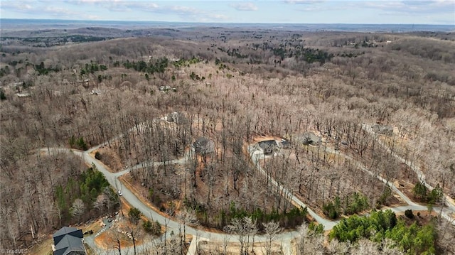 drone / aerial view with a wooded view