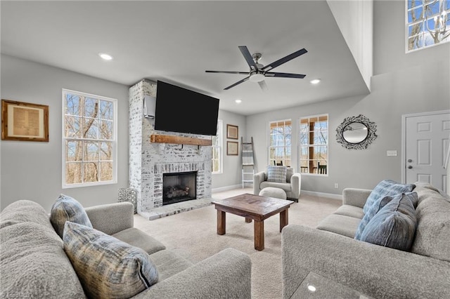 carpeted living room with ceiling fan, baseboards, a brick fireplace, and recessed lighting