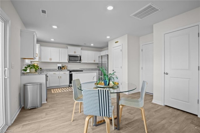 dining space with light hardwood / wood-style floors