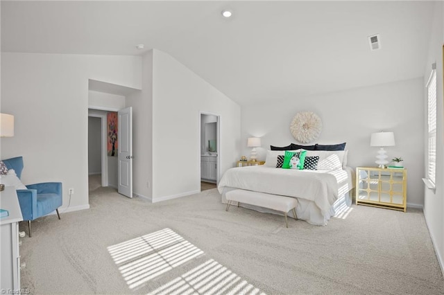 carpeted bedroom with lofted ceiling and ensuite bath