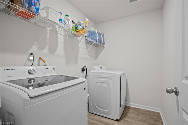 washroom featuring hardwood / wood-style flooring and washer and clothes dryer