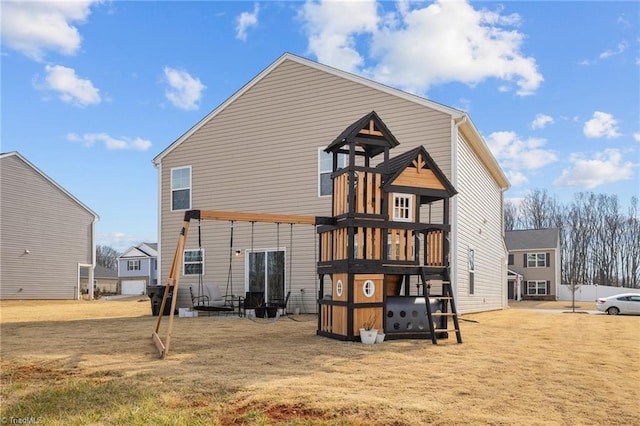 rear view of property featuring a playground