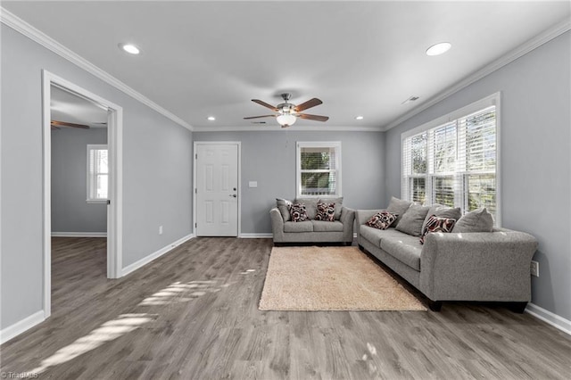 living room with hardwood / wood-style floors, ceiling fan, and crown molding