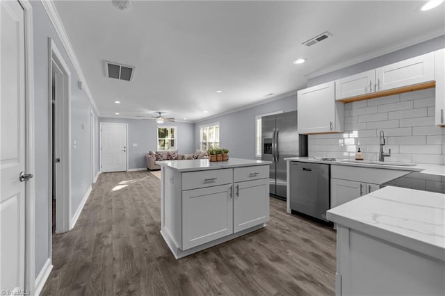 kitchen featuring sink, white cabinetry, ceiling fan, backsplash, and appliances with stainless steel finishes