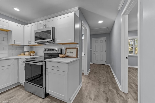 kitchen with appliances with stainless steel finishes, white cabinets, and tasteful backsplash