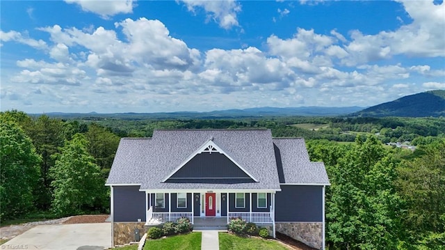 7768 Pinecone Ln, Hickory, NC 28602 - view of front of home with covered porch, stone siding, a wooded view, and roof with shingles