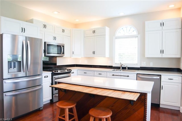 7768 Pinecone Ln, Hickory, NC 28602 - kitchen featuring appliances with stainless steel finishes, a sink, white cabinets, dark wood finished floors, and recessed lighting