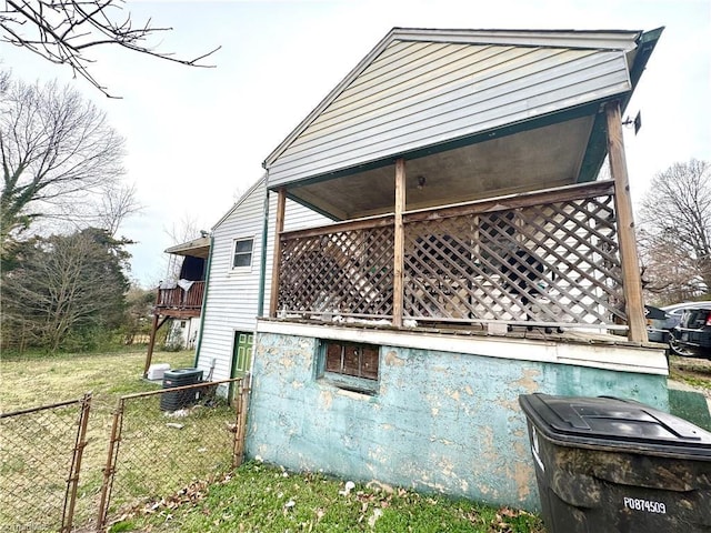 view of side of property with a gate, a balcony, and fence