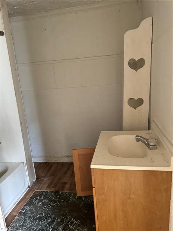 bathroom with vanity, hardwood / wood-style flooring, and a washtub