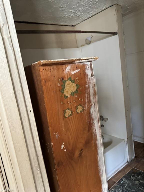 bathroom featuring wood-type flooring and a tub to relax in