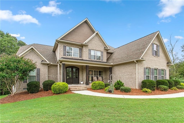 view of front of property with a front lawn, french doors, and covered porch