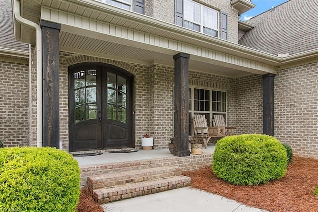 entrance to property with french doors and a porch