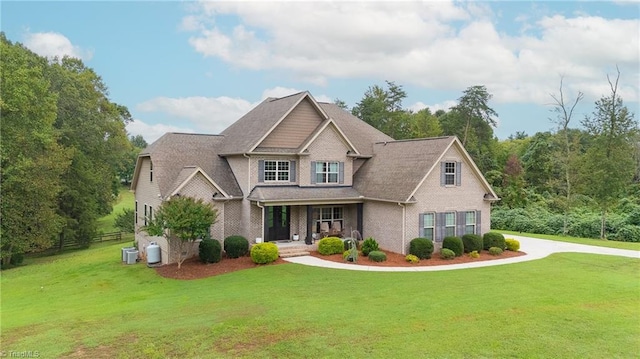 craftsman inspired home featuring a front lawn, covered porch, and central AC