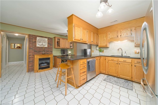 795 Morris Rd, Winston-Salem, NC 27101 - kitchen featuring a sink, appliances with stainless steel finishes, a peninsula, dark countertops, and decorative backsplash