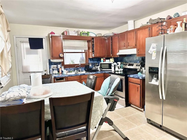 kitchen with appliances with stainless steel finishes, sink, and backsplash