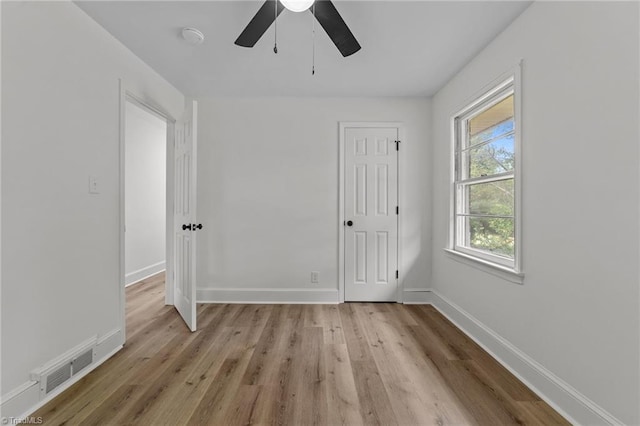 spare room with a ceiling fan, light wood-type flooring, baseboards, and a smoke detector
