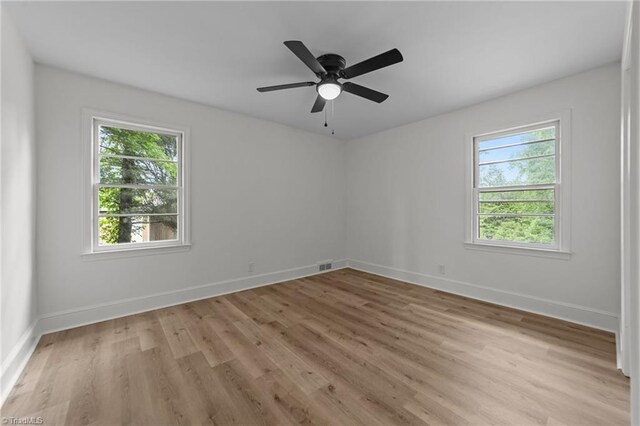 unfurnished room with healthy amount of natural light, light wood-type flooring, baseboards, and a ceiling fan