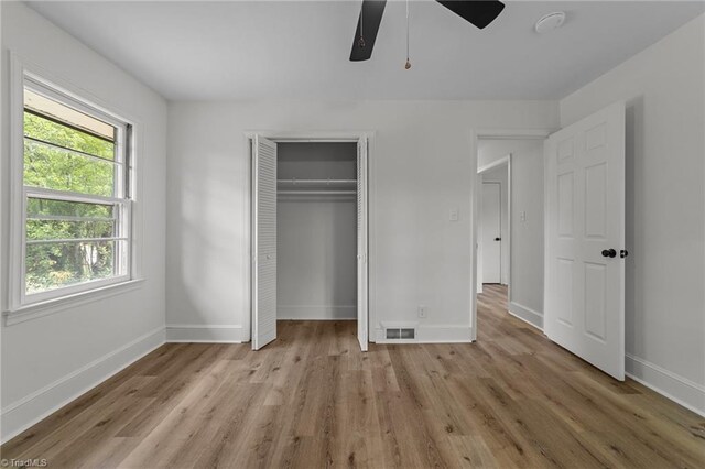 unfurnished bedroom featuring light wood-type flooring, baseboards, and a closet